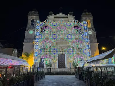 a large building with a lit up facade with a clock tower at FLA' Suite Deluxe in Terrasini
