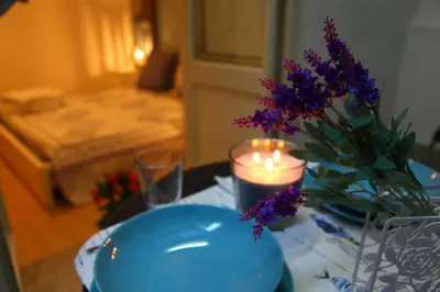 a candle and a vase with purple flowers on a table at Vacanze Palermitane in Palermo