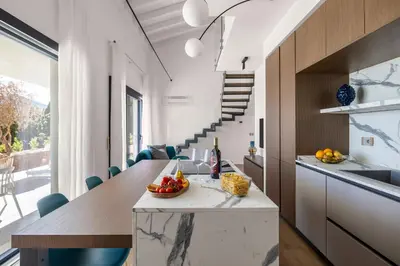 a kitchen and dining room with a long table and blue chairs at Villa Adler Nature&Relax in Scopello