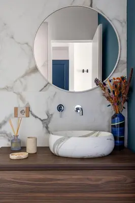 a bathroom with a round mirror on a wooden table at Villa Adler Nature&Relax in Scopello