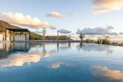 a pool of water in front of a building at Villa Adler Nature&Relax in Scopello
