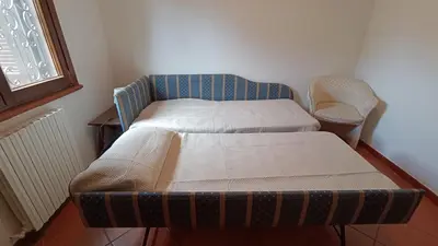 a small room with a bed and a chair at Villetta Milù in Palermo