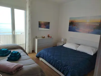 a bedroom with a blue bed and a window at Bellavista in Santa Flavia