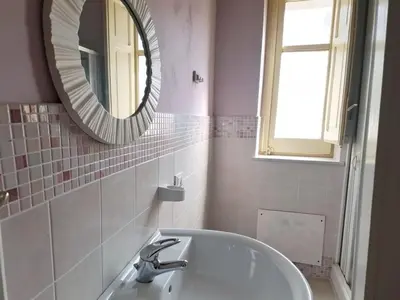 a white bathroom with a sink and a mirror at Summer Breeze Apartments in Trappeto