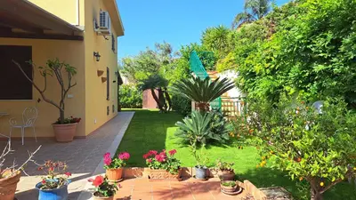 a garden with potted plants and flowers on a patio at Villa Agae in Trabia