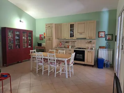 a kitchen with a table and chairs and a stove at Villa Agae in Trabia