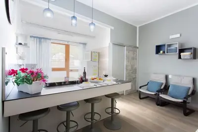 a kitchen with a counter and stools in a room at A 2 passi dal castello ,appartamento con veranda in Castellammare del Golfo