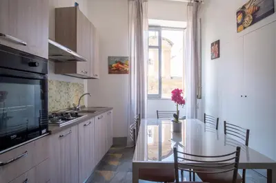 a kitchen with a table with chairs and a window at ROME 118 intero appartamento in Palermo