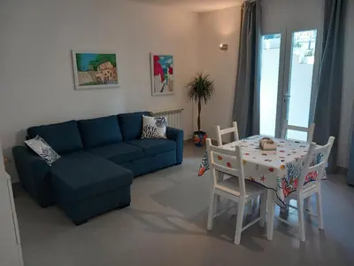 a living room with a blue couch and a table at Villa Costa Mondello in Palermo