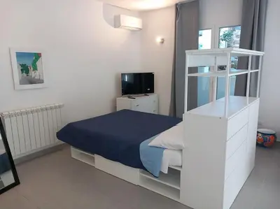 a small bedroom with a bed and a television at Villa Costa Mondello in Palermo