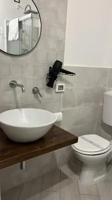 a bathroom with a sink and a toilet and a mirror at Calatafimi Rocca Home in Palermo