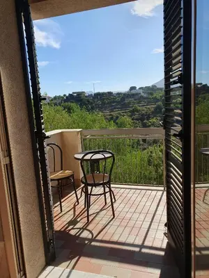 a patio with a table and chairs on a balcony at Nika Holiday Home in Casteldaccia