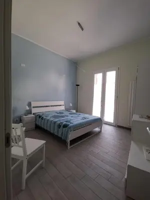 a bedroom with a bed and a chair in it at Casa vacanze Haliotis in Isola delle Femmine