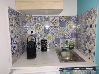 a kitchen with a sink and tiles on the wall at Casa vacanze Haliotis in Isola delle Femmine
