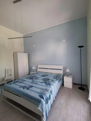 a bedroom with a large bed with a blue blanket at Casa vacanze Haliotis in Isola delle Femmine