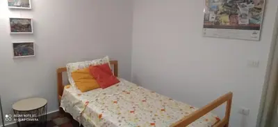 a small bedroom with a bed with colorful pillows at Star Apartment at the Cathedral in Palermo