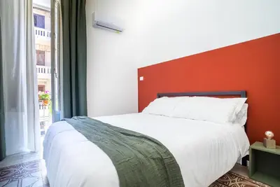 a bedroom with a large bed with a red headboard at Picciridda Rooms in Palermo