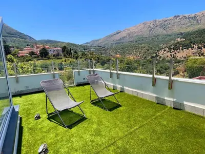 two chairs on a balcony with a view of mountains at Panoramica Via Villa in Carini