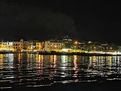 a city lit up at night with a body of water at La casetta di gra in Palermo