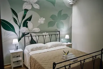 a bedroom with a bed with flowers on the wall at Trinacria Caccamo - Luxury Rooms in Caccamo