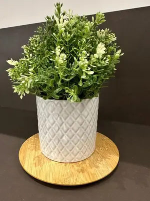 a white vase with a plant in it on a table at Lily Suite 10 in Palermo