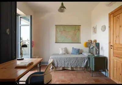 a bedroom with a bed and a table and a desk at VILLA AZUL in Castellammare del Golfo