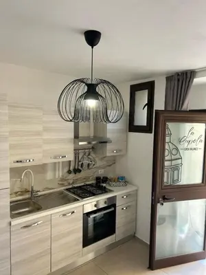 a kitchen with a stove and a chandelier at La Cupola - casa vacanze n 10 in Termini Imerese