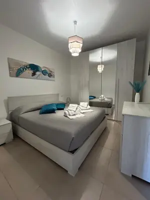 a bedroom with a large bed with blue pillows at La Cupola - casa vacanze n 10 in Termini Imerese