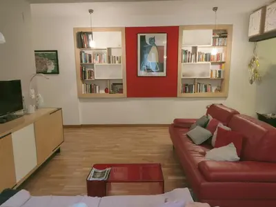 a living room with a red wall and a couch at Casa Anita In centro in Palermo
