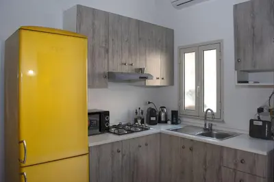 a yellow refrigerator in a kitchen with wooden cabinets at LA CASA DELL'EMIRO in Misilmeri