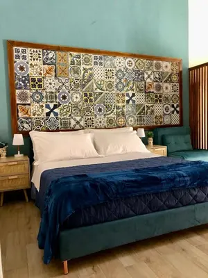 a bedroom with a large bed with a mosaic wall at LA CASA DELL'EMIRO in Misilmeri