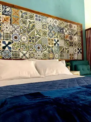 a bedroom with a bed with a wall covered in tiles at LA CASA DELL'EMIRO in Misilmeri