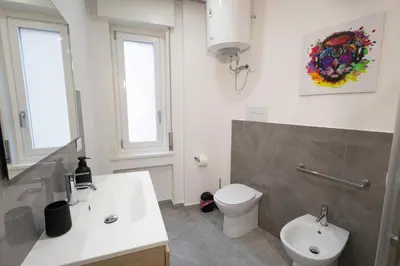 a bathroom with a white sink and a toilet at Politeama Suite in Palermo