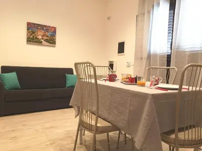 a living room with a table with chairs and a couch at Nora’s Home in Palermo