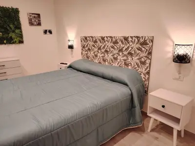 a bedroom with a bed and a nightstand and a bed sidx sidx sidx sidx at Nora’s Home in Palermo