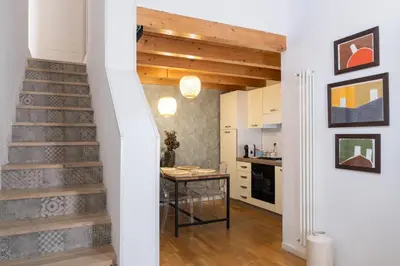 a stairway leading to a kitchen with a table at La Cecia Home in Castellammare del Golfo