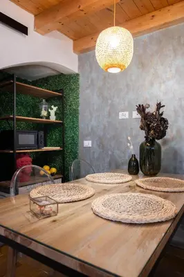 a table with five plates on it with a light fixture at La Cecia Home in Castellammare del Golfo