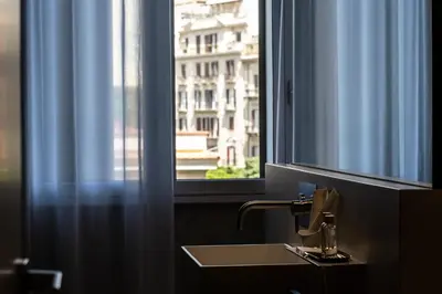a bathroom with a sink and a window at Amorgiù Luxury Suites in Palermo