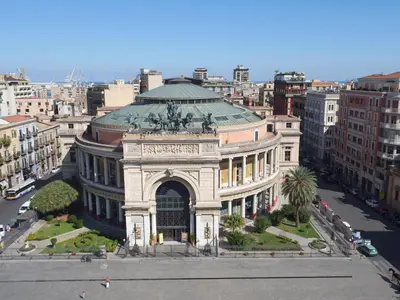 a building with a statue in the middle of a city at Amorgiù Luxury Suites in Palermo