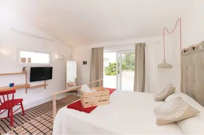 a hotel room with a bed and a desk and a television at Villa delle Sterlizie con piscina e jacuzzi by Le Dhome Sicily in Partinico