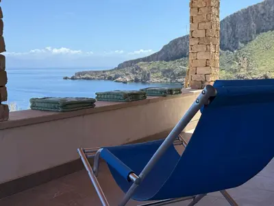 a blue chair sitting on a balcony overlooking the ocean at Chalet Tango in Contrada Sauci Grande