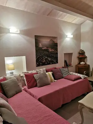 a living room with a large couch with pink sheets at Chalet Tango in Contrada Sauci Grande