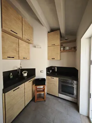 a small kitchen with wooden cabinets and a stove at Chalet Tango in Contrada Sauci Grande