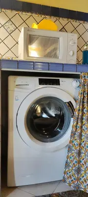 a washing machine with a microwave on top of it at Maison al-Aziz in Palermo