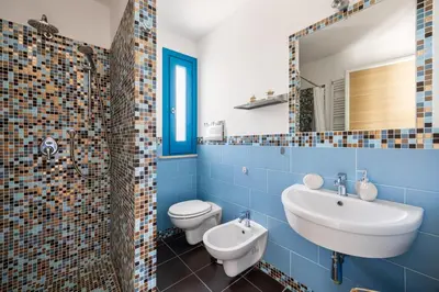 a bathroom with a sink and a toilet and a mirror at Villa Celeste in Castellammare del Golfo