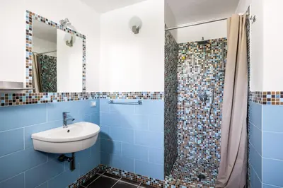 a blue bathroom with a sink and a shower at Villa Celeste in Castellammare del Golfo