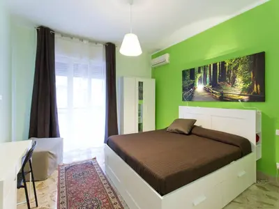 a bedroom with green walls and a large bed at La Favorita - Ben collegato con l'aeroporto, la spiaggia di Mondello e il centro città in Palermo