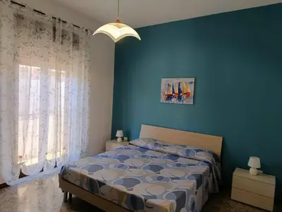 a bedroom with a bed and a blue wall at Casa Vacanza Zá Cicciuzza in Isola delle Femmine