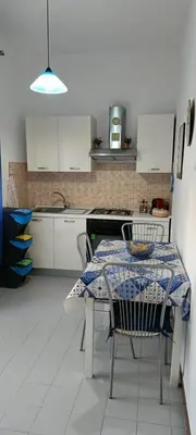 a kitchen with a table with chairs and a table and a table at Casa Vacanza Zá Cicciuzza in Isola delle Femmine