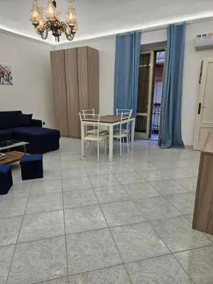 a living room with a couch and a table and chairs at Fauka blu in Carini